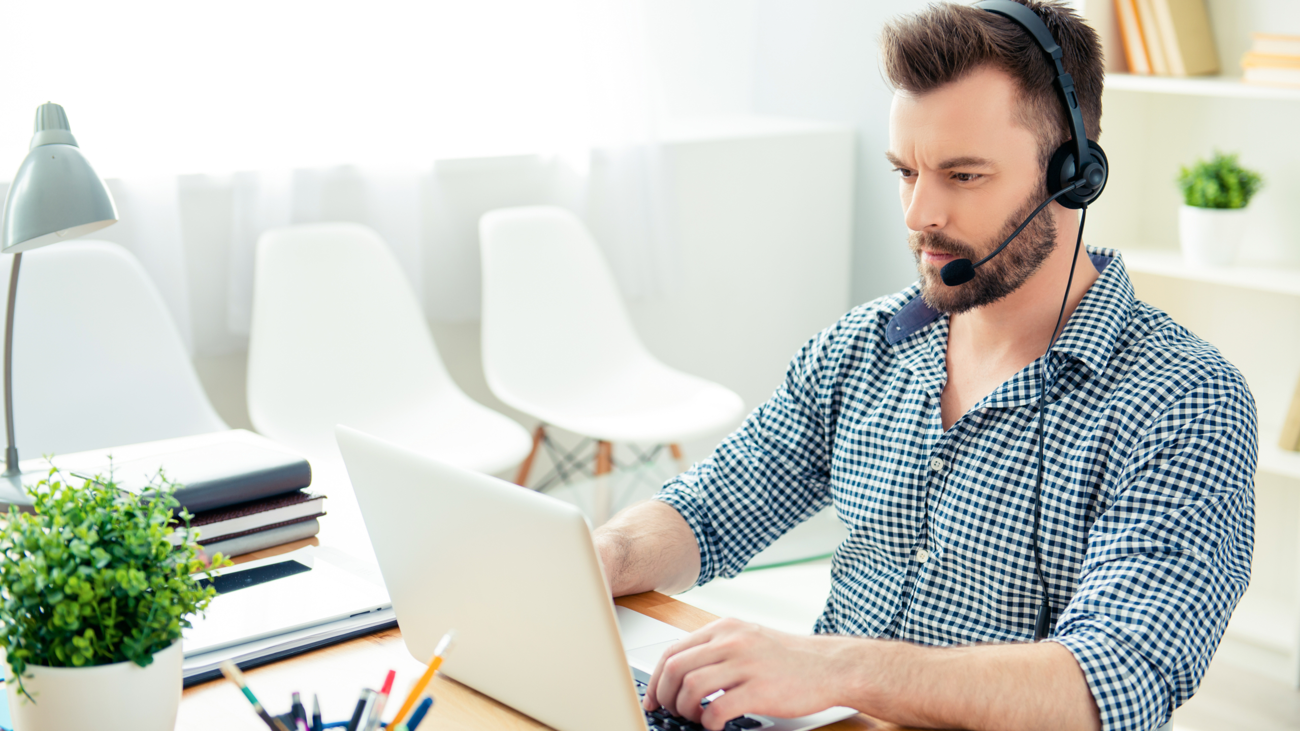Office worker wearing headset to access VoIP business phone system. 