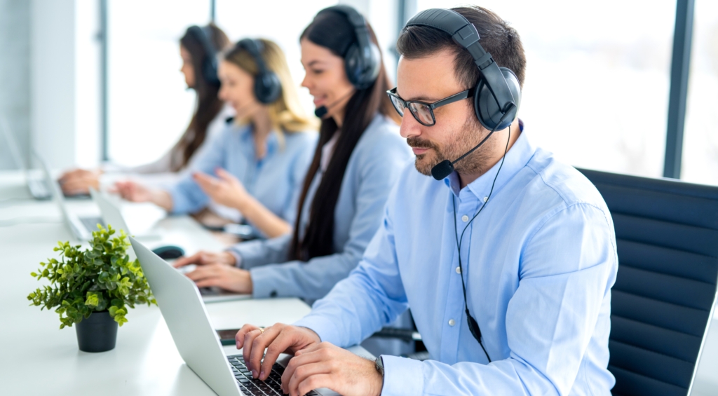 Contact centre workers speaking on video calls on a laptop via a CCaaS solution. 