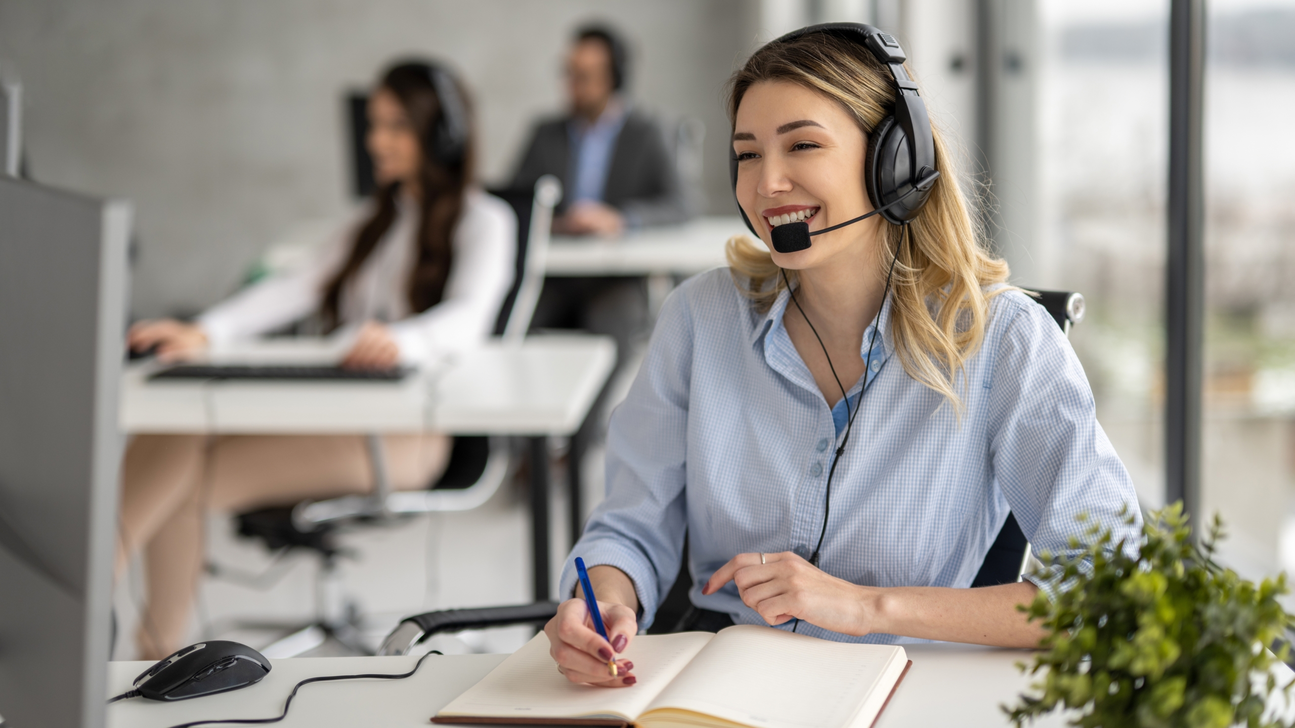 Smiling female call centre worker using a unified communications headset. 