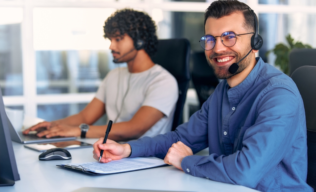 Smiling male office worker wearing unified communications headset. 